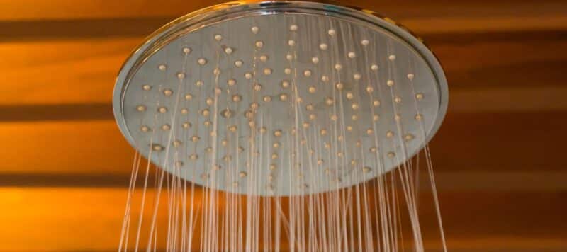 closeup of a shower head with water running out of it