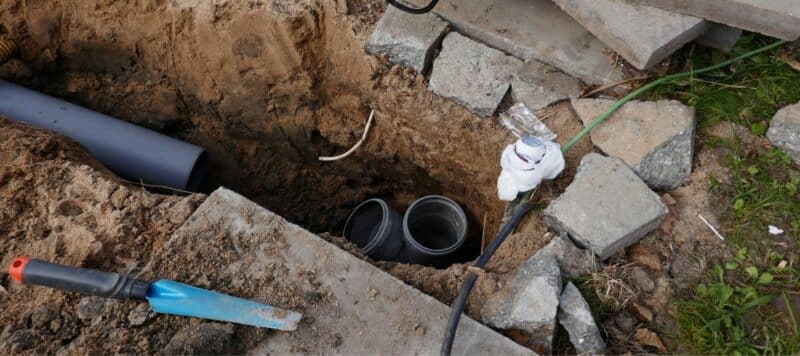 sewer line repair in progress. Exposed sewer pipe in the ground