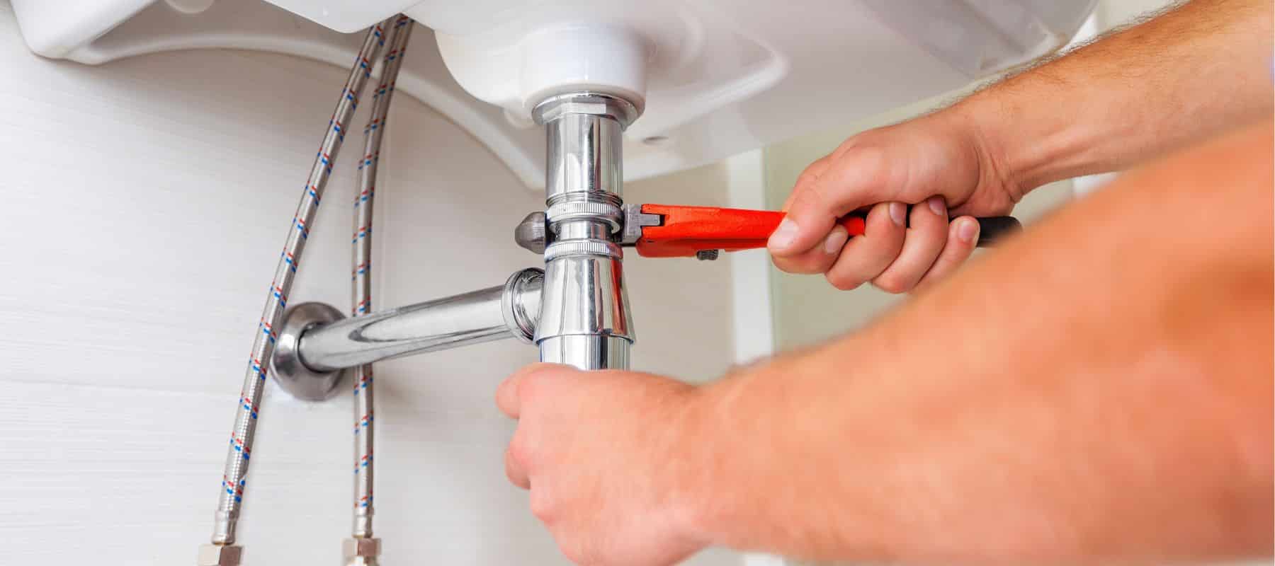 plumber using a wrench to tighten a pipe