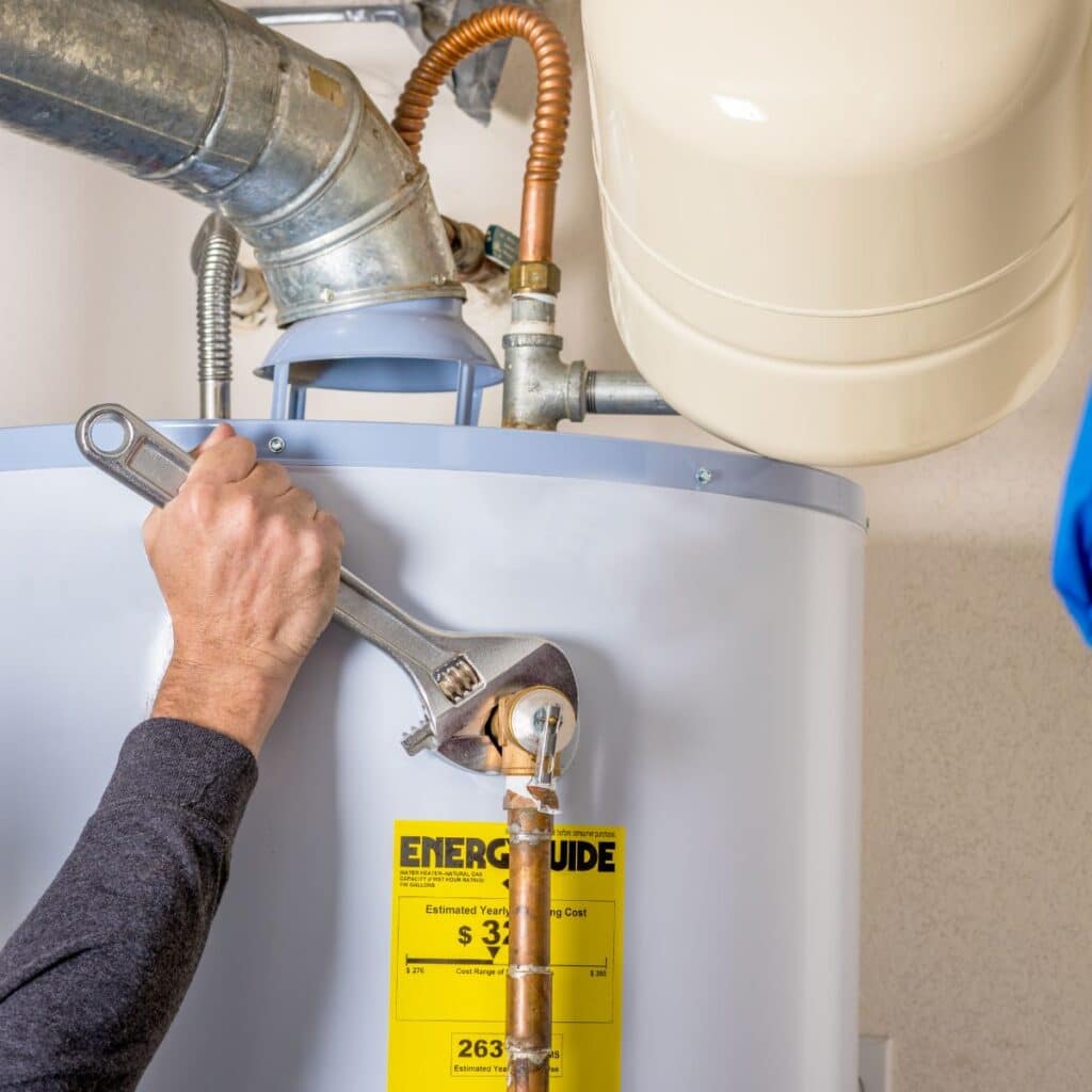 plumbing tech that is tightening the fitting on a hot water heater