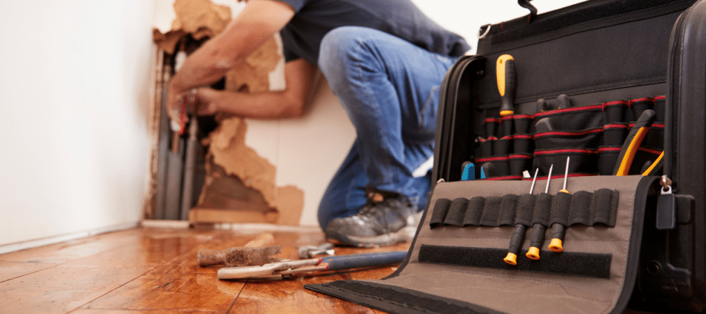 close up of a plumbers tools while he is assessing a leak in the wall
