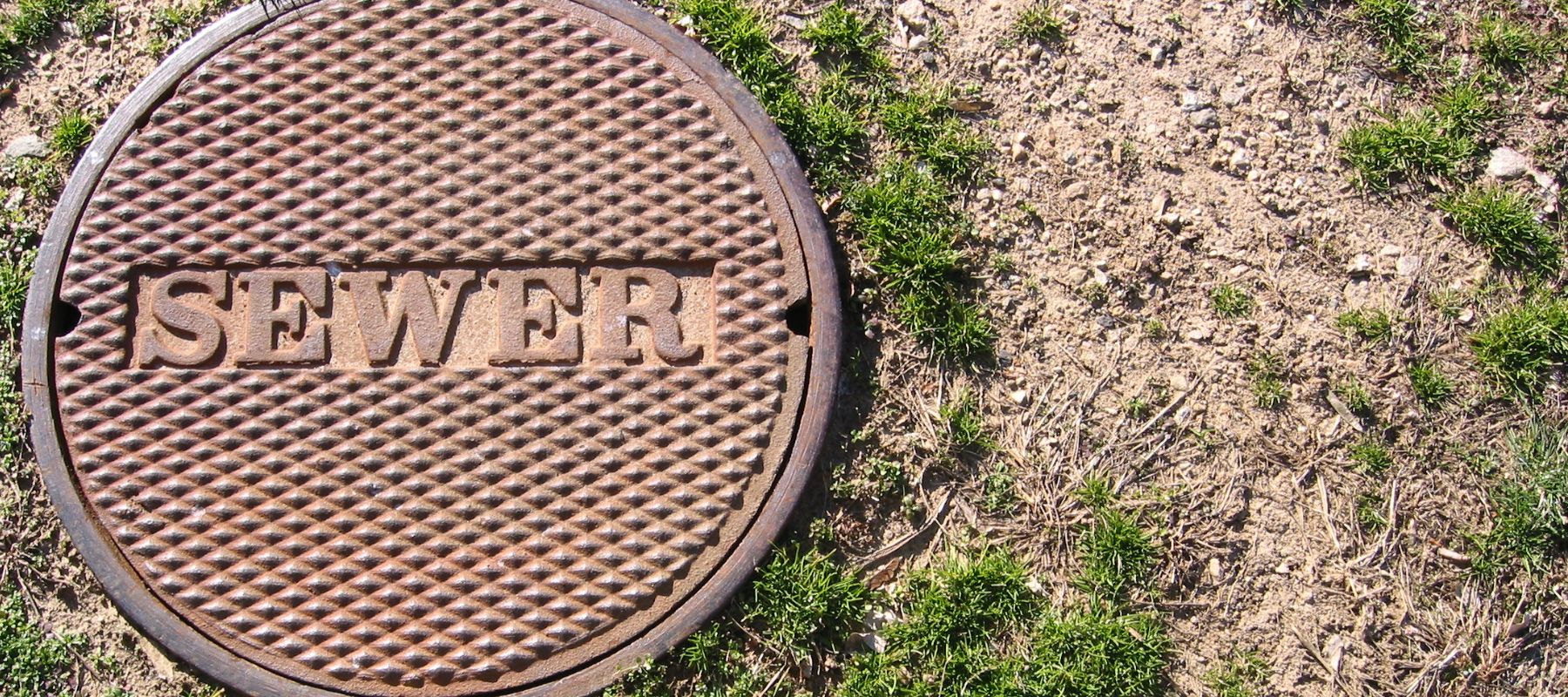 sewer manhole cover in a yard