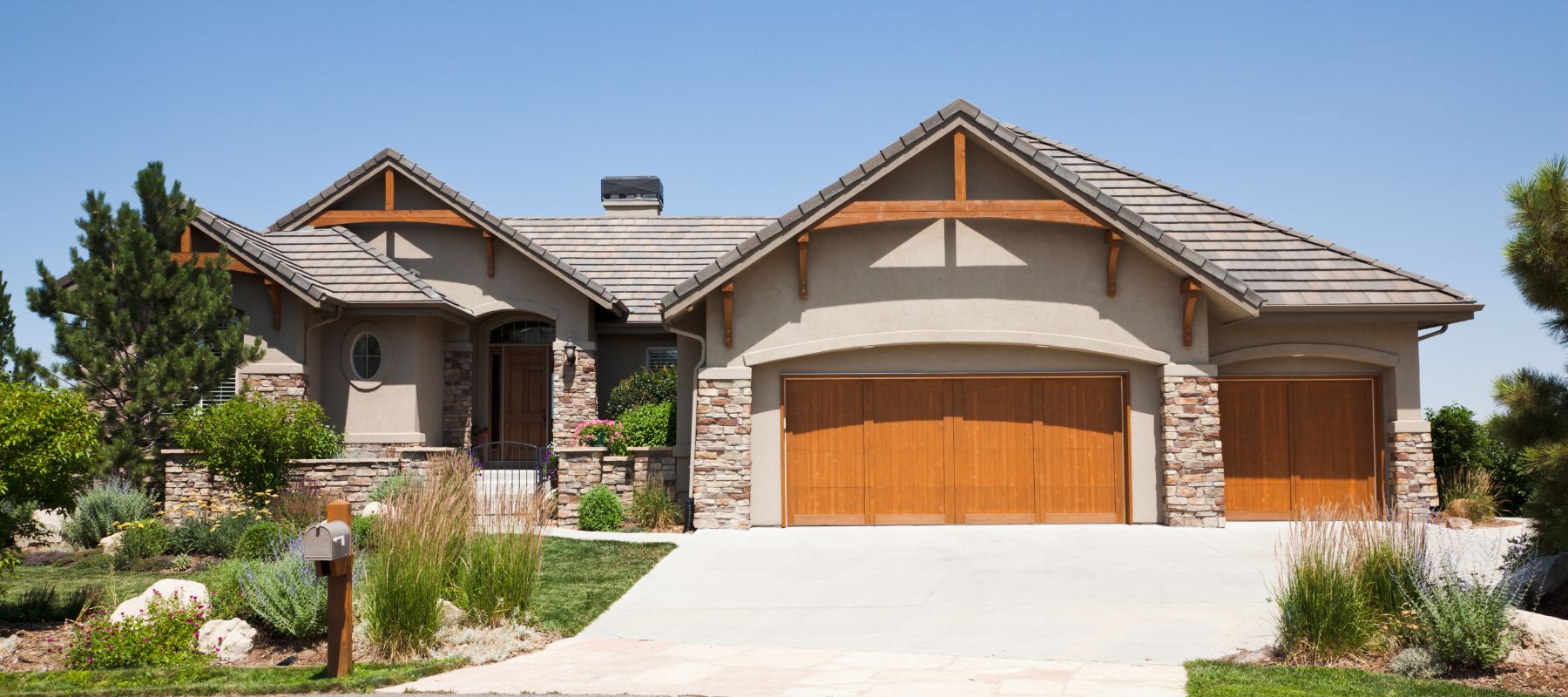 front of a one-story home in glendale colorado with an orange wood garage door