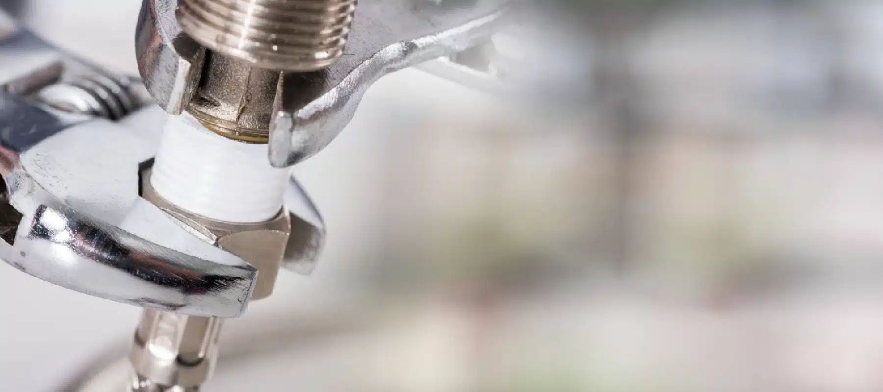 plumber using a wrench to tighten a pipe