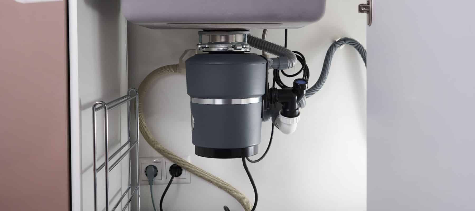 close up of dark gray garbage disposal installed under a kitchen sink
