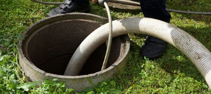 closeup of a large cleaning hose in a sewer line manhole for sewer line cleaning